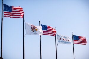 Image containing the United States flag, Illinois state flag, and city of Chicago flag.